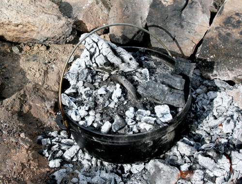 Dutch oven covered by coals